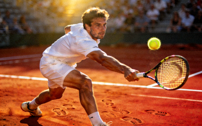 网球运动员在红土场地上奋力挥拍击球的专业动作